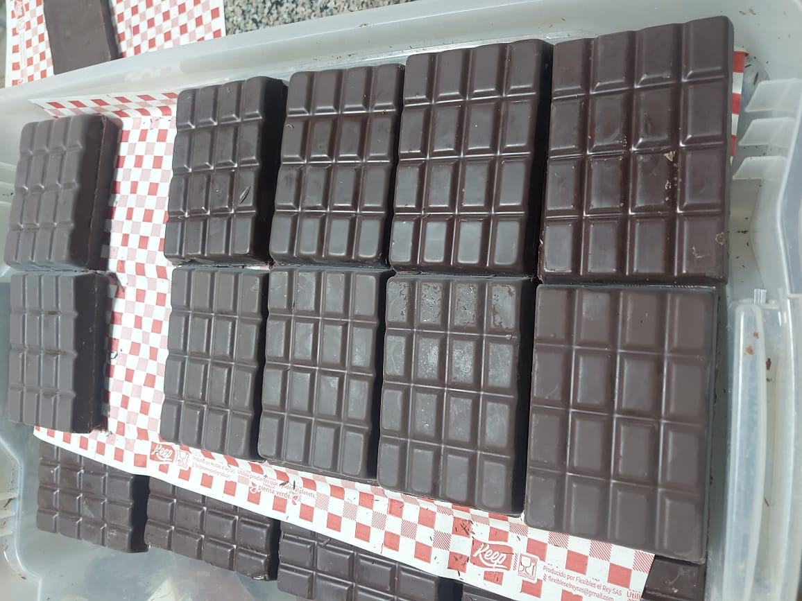 Production-scale stacked dark chocolate bars made from FLZ-03 cacao, on the family farm.