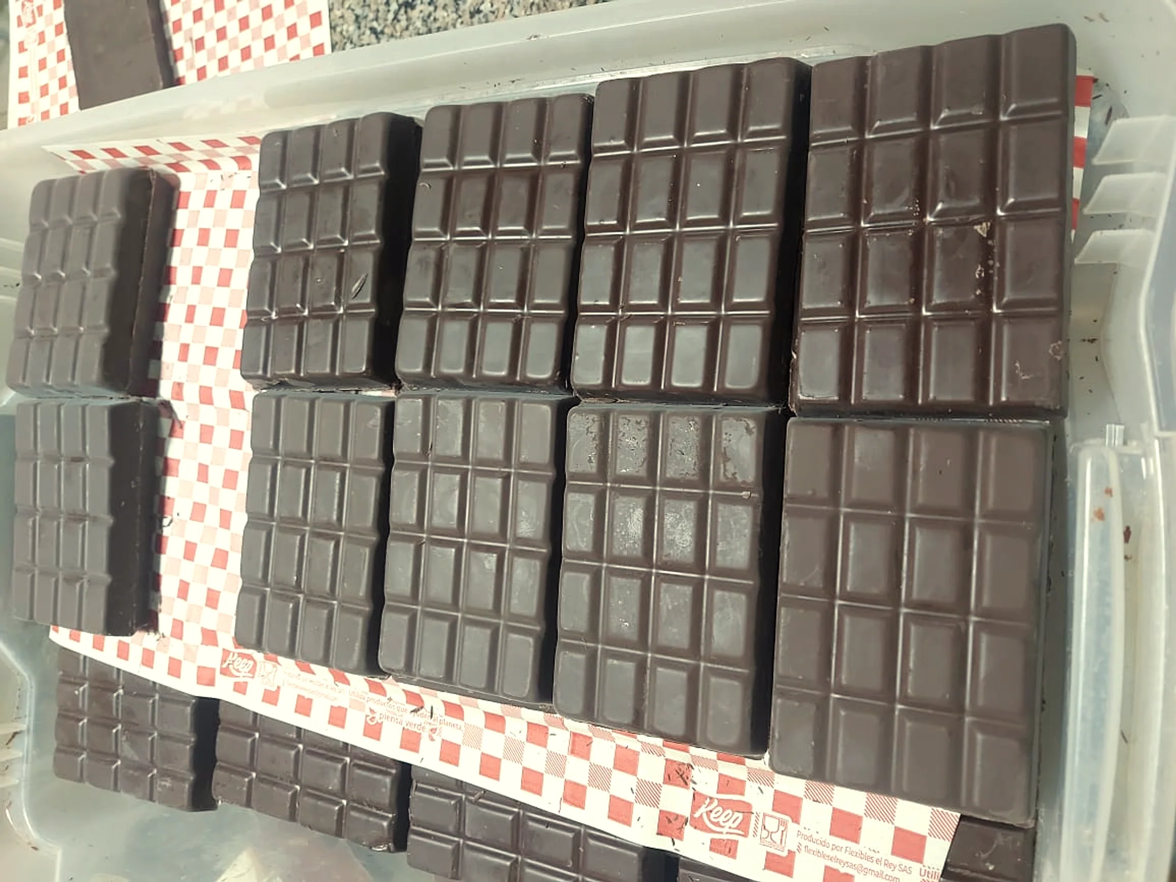 Finished chocolate bars cooling in their molds, the surface still glossy, the air still warm from the temper.